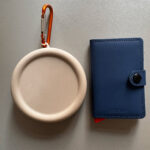Chipolo x Secrid Trackable Miniwallet neben Kleingeldbörse.