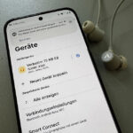 Einstellungen vornehmen: Verbatim Neckband Kopfhörer neben Android Smartphone 